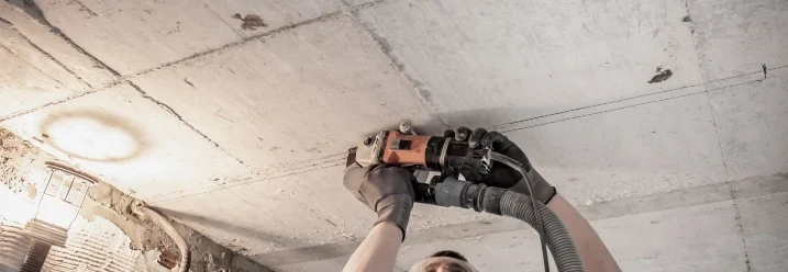 Person bearbeitet Zimmerdecke mit Fräse